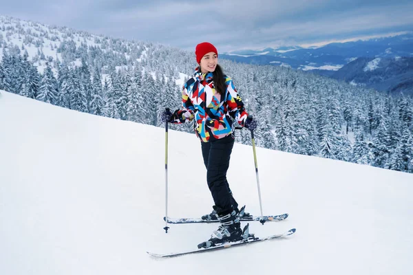 Vacker kvinna på skidor pisten på snöiga resort. Vintersemester — Stockfoto