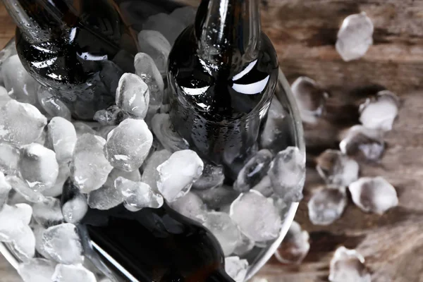 Ahşap arka plan, closeup buza bira şişesi ile kase