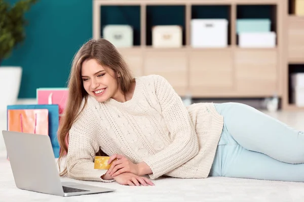 Jovem mulher compras online com cartão de crédito e laptop no chão — Fotografia de Stock