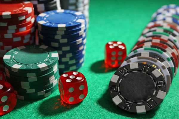 Čipy a kostky na zeleném stole v kasinu — Stock fotografie