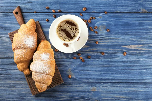 Croissant lezat dan secangkir kopi di atas meja kayu — Stok Foto