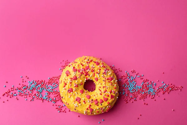 Вкусный желтый пончик на цветном фоне — стоковое фото