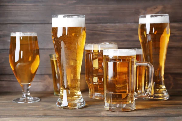 Glassware with fresh beer on wooden background — Stock Photo, Image