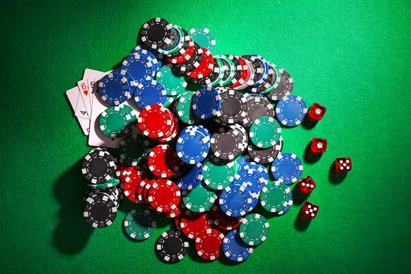 Žetony na poker a kostky na zeleném stole v kasinu — Stock fotografie