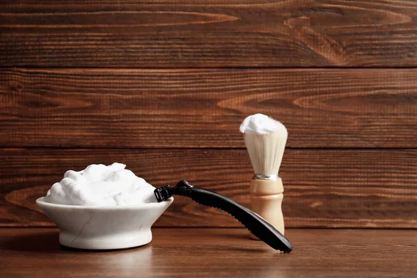 Перукарська щітка, піна для гоління та бритва для людини на столі — стокове фото