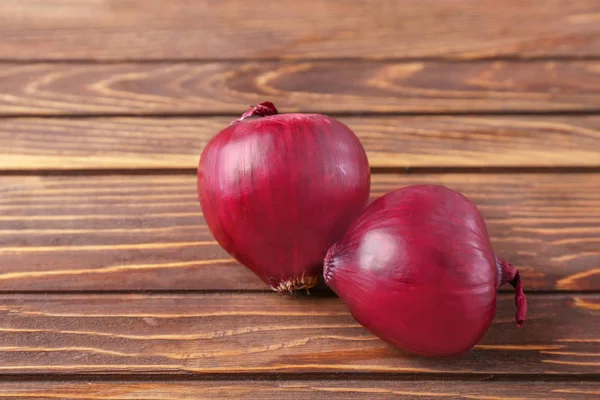 Rote Zwiebel auf hölzernem Hintergrund — Stockfoto