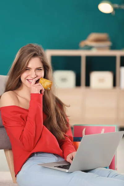 Jovem mulher compras on-line com cartão de crédito e laptop em casa — Fotografia de Stock