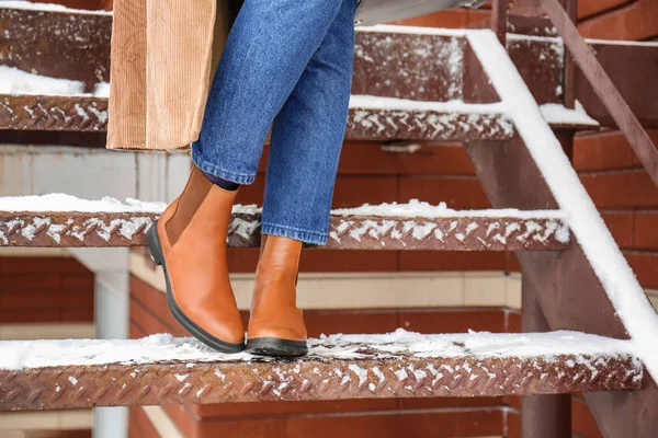 Femme élégante dans des chaussures chaudes sur les escaliers en hiver — Photo