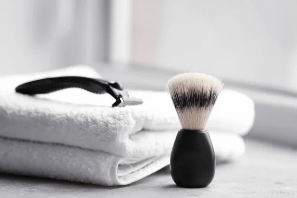 Cepillo de afeitar, toalla y afeitadora para hombre en la mesa —  Fotos de Stock