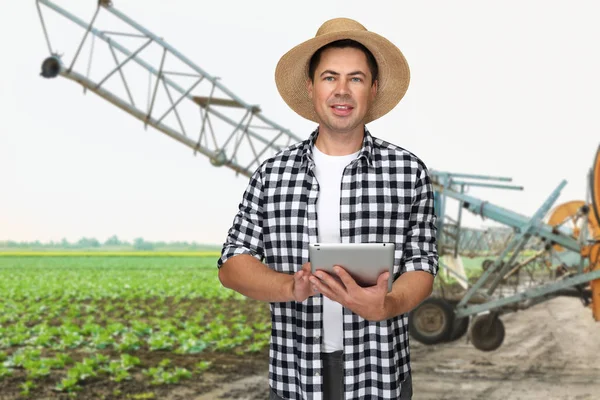 Agronomista com tablet moderno em pé no campo — Fotografia de Stock