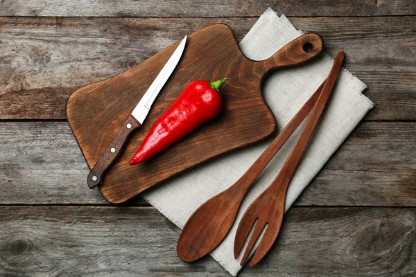 Utensílios de cozinha e pimenta em fundo de madeira — Fotografia de Stock