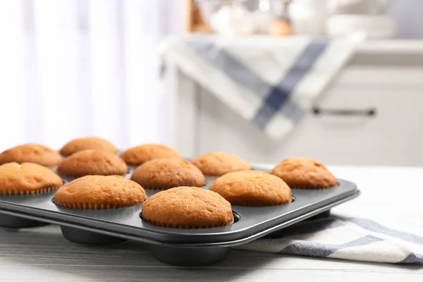 Bandeja de cozimento com cupcakes saborosos na mesa. Fresco do forno — Fotografia de Stock