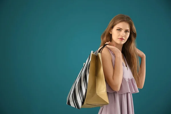 Красива молода жінка з сумками на кольоровому фоні — стокове фото