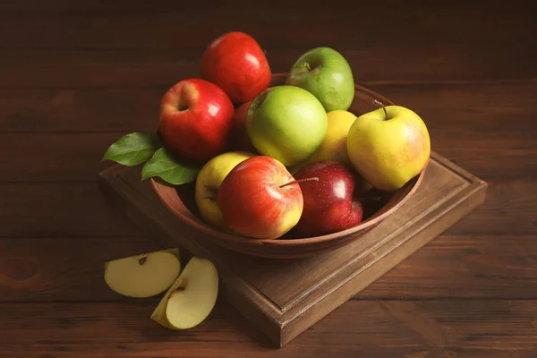 Plaat met rijpe sappige appels op houten tafel — Stockfoto