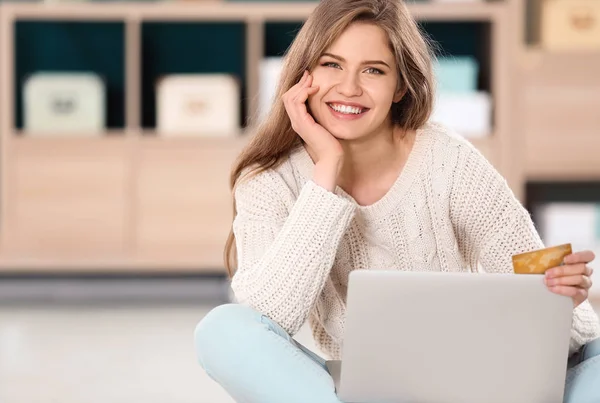 Jonge vrouw winkelen online met credit card en laptop op verdieping — Stockfoto