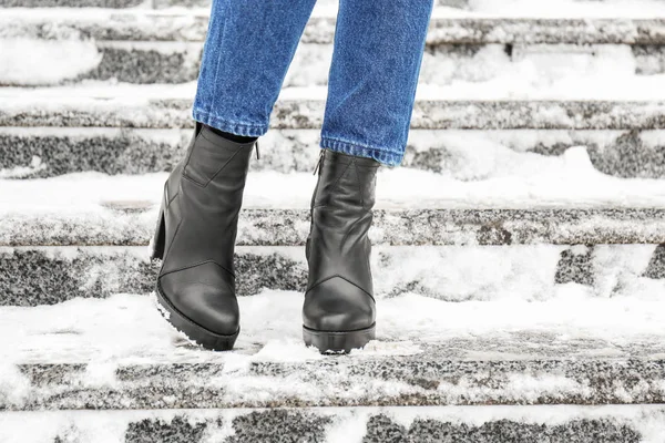 Стильная женщина в теплой обуви на городской улице зимой — стоковое фото