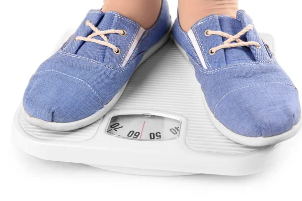 Overweight girl standing on floor scales against white background — Stock Photo, Image