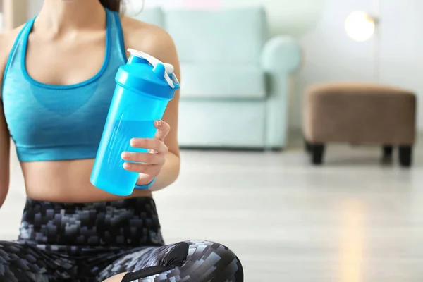 Güzel sportif kadın fitness egzersizleri evde yaptıktan sonra su şişe — Stok fotoğraf