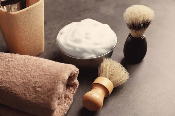 Spazzole da barbiere, asciugamani e schiuma da barba per uomo sul tavolo — Foto Stock