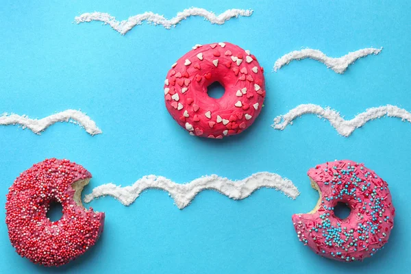 Hermosa composición con deliciosas rosquillas en el fondo de color —  Fotos de Stock