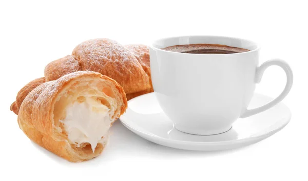 Croissants saborosos com creme e xícara de café no fundo branco — Fotografia de Stock