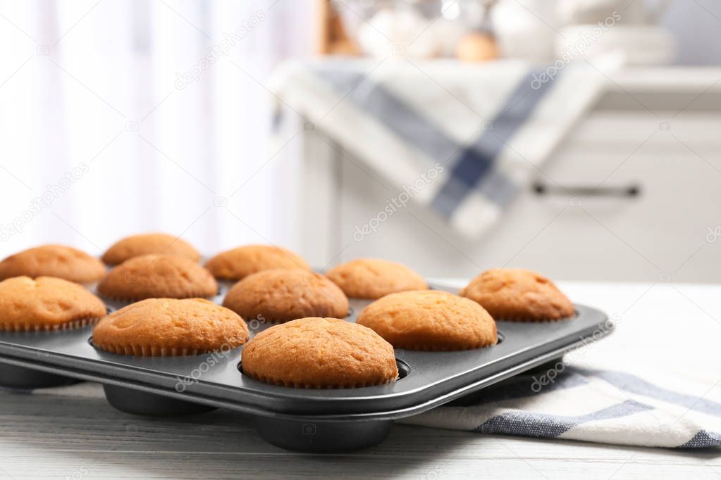Baking tray with tasty cupcakes on table. Fresh from oven