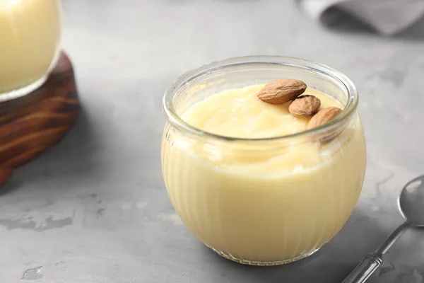 Botol Kaca Dengan Puding Vanili Dengan Almond Atas Meja — Stok Foto