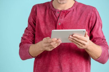 Tablet bilgisayar renk arka plan üzerinde kullanan adam