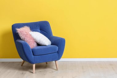 Renk duvarının yakınında yumuşak yastık ile rahat koltuk