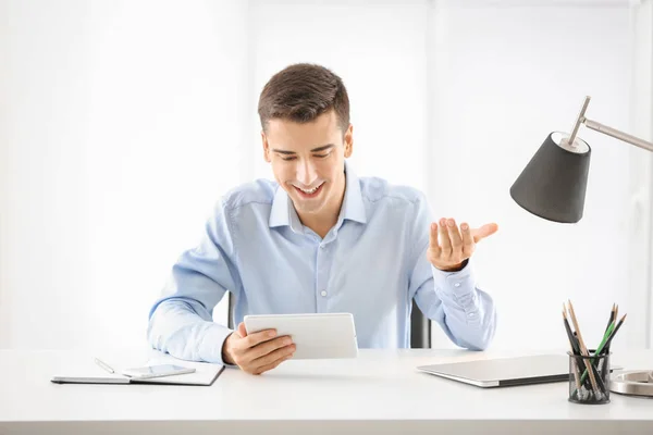 Hombre joven usando tableta en la mesa en el interior —  Fotos de Stock