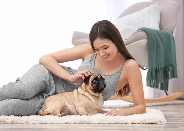 Una mujer con un lindo perro en casa. Amistad entre mascota y dueño —  Fotos de Stock