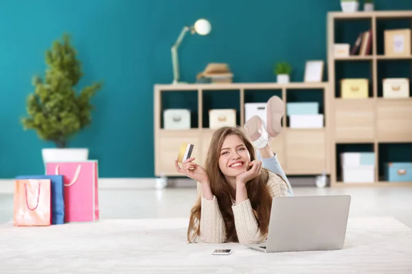 Mladá žena nakupování online s kreditní kartou a laptop na podlaze — Stock fotografie