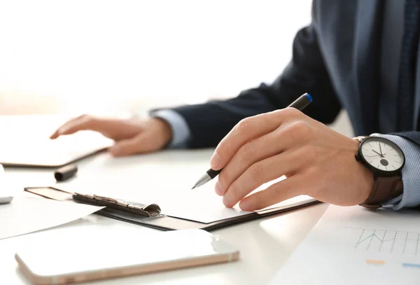 Jovem que trabalha à mesa no escritório. Conceito de serviço de consultoria — Fotografia de Stock