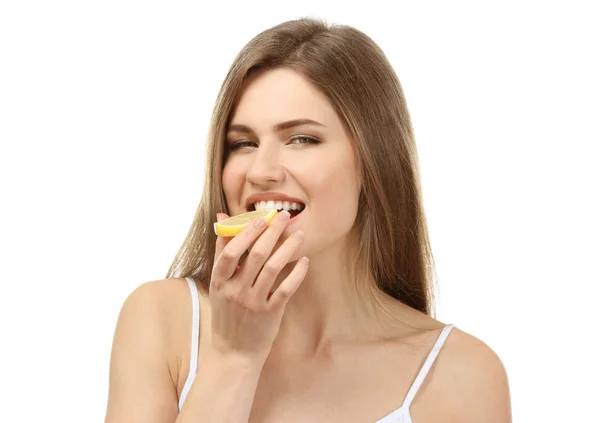 Belle jeune femme mangeant du citron mûr sur fond blanc — Photo