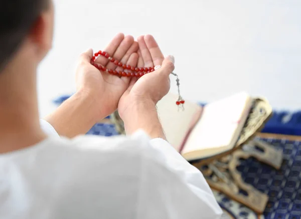 Genç Müslüman erkek Kur'an katta üzerinde dua boncuklar ile — Stok fotoğraf