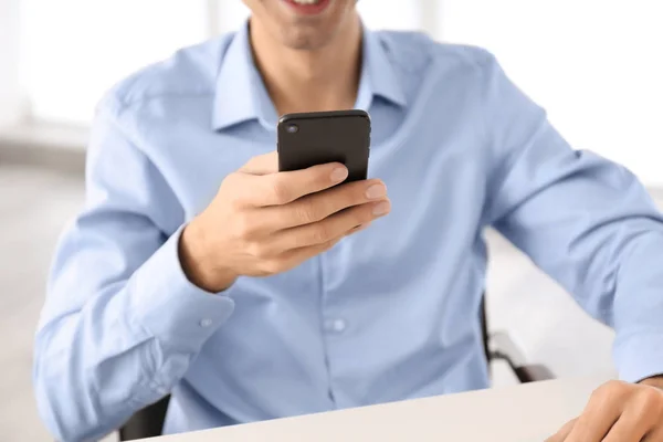 Jovem usando telefone na mesa dentro de casa — Fotografia de Stock