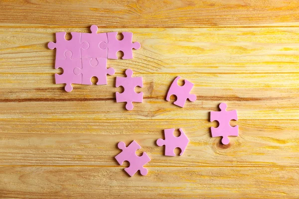 Puzzle pieces on wooden background. Unity concept — Stock Photo, Image
