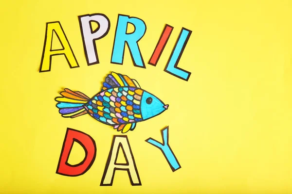 Phrase "April day" and drawing of fish on color background — Stock Photo, Image