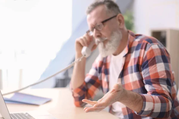 Bărbat în vârstă vorbind la telefon la locul de muncă în birou — Fotografie, imagine de stoc