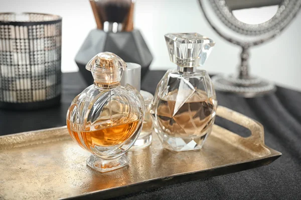 Bandeja de metal con frascos de perfume sobre mesa — Foto de Stock