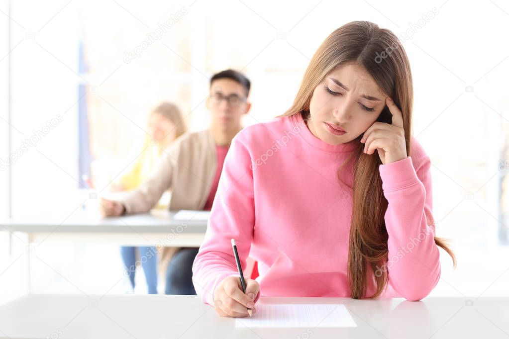 Female student taking exam in classroom