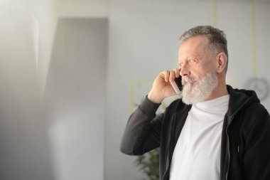 İşyeri ofis cep telefonunda konuşan üst düzey adam