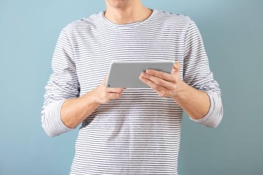 Tablet bilgisayar renk arka plan üzerinde kullanan adam