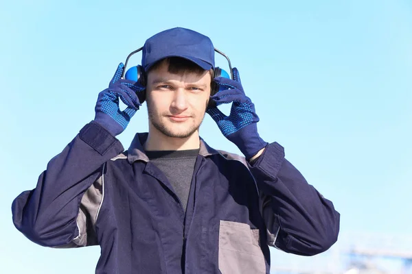 Hombre trabajador con auriculares al aire libre. Equipo de protección auditiva —  Fotos de Stock