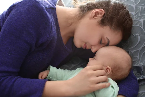 Young mother with sleeping baby at home — Stock Photo, Image