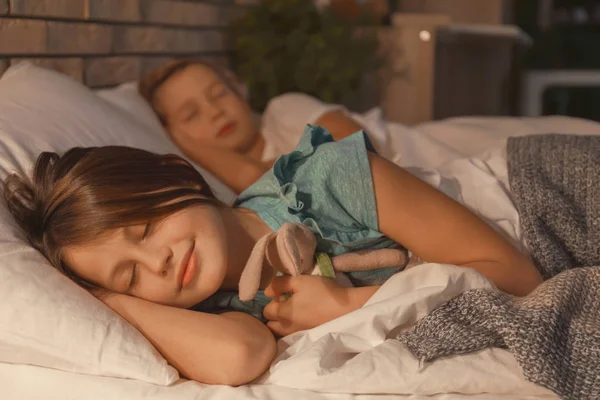 Söta lilla syster och bror sover i sängen hemma — Stockfoto