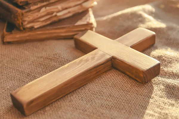 Cruz de madera y libros antiguos sobre tela de saco —  Fotos de Stock