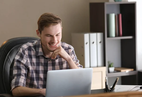 Young man working with laptop indoors — Stock Photo, Image