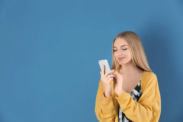 Belle jeune femme avec téléphone mobile sur fond de couleur — Photo