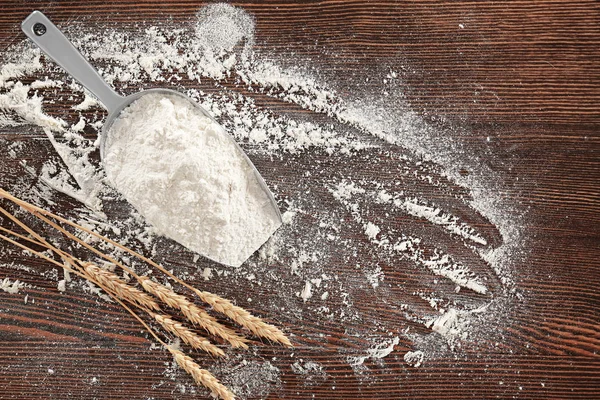 Pala con harina de trigo y espiguillas sobre mesa de madera —  Fotos de Stock